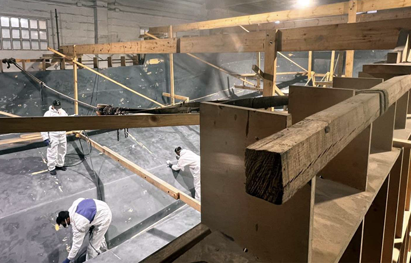 Workers operating inside a hull at Samala Shipyard during naval construction process